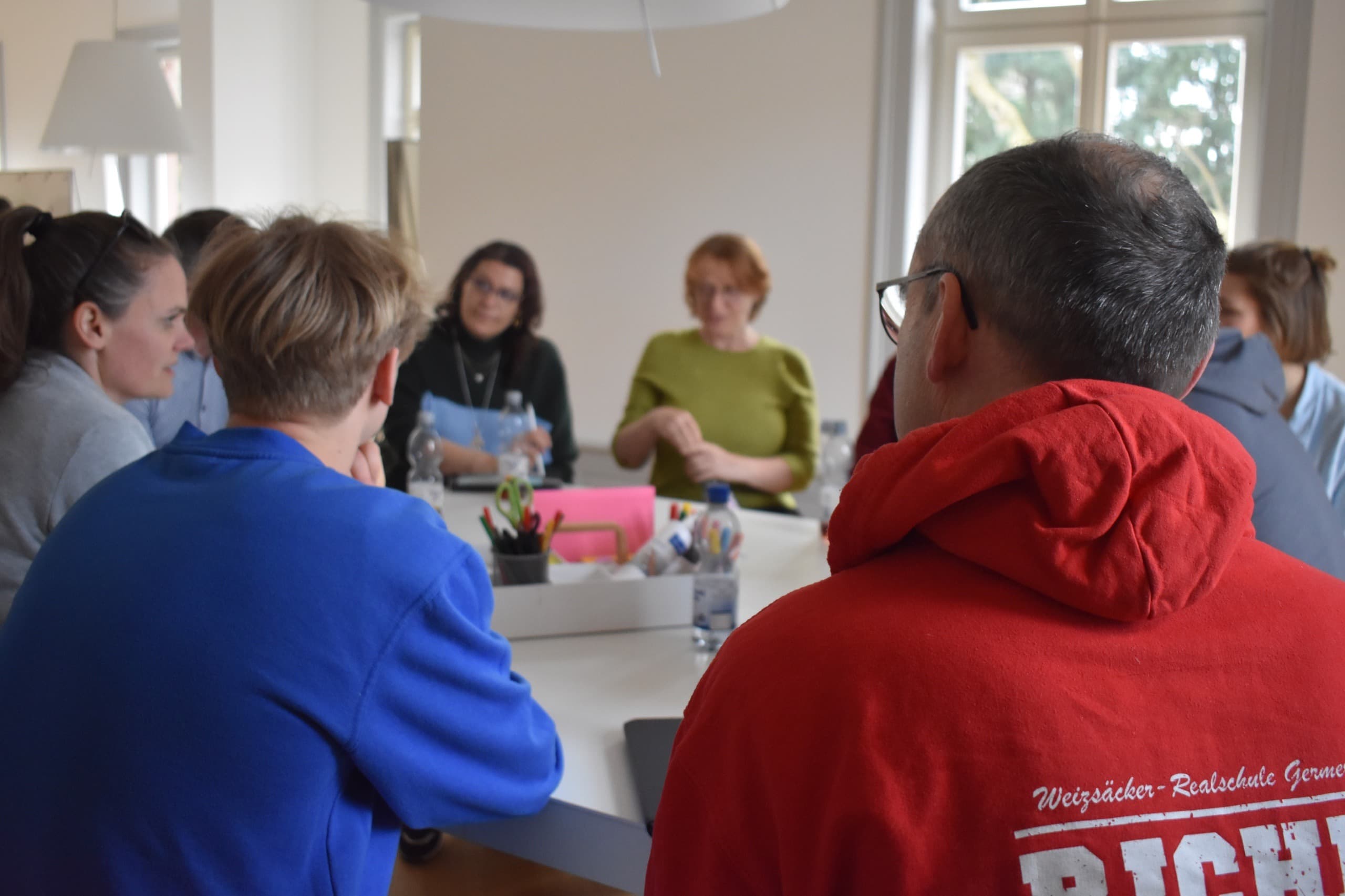 Teilnehmende sitzen bei einem Netzwerktreffen an einem Tisch.