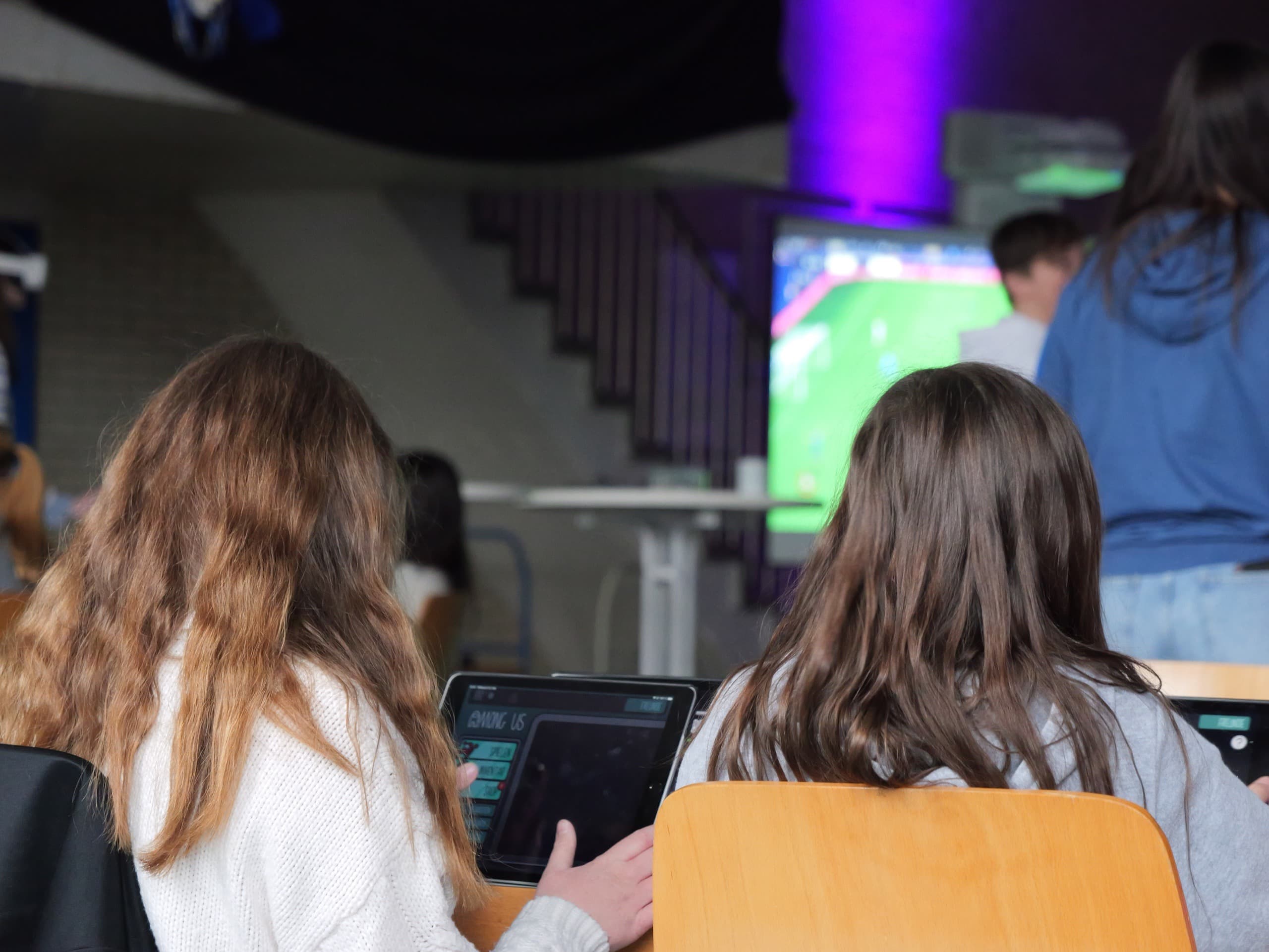 Kinder und Jugendliche erproben ein digitales Lernangebot an einem großen Bildschirm.