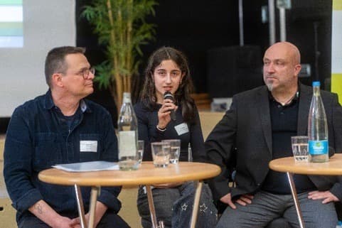 Jugendliche Teilnehmerin spricht bei einem Podiumsgespräch.